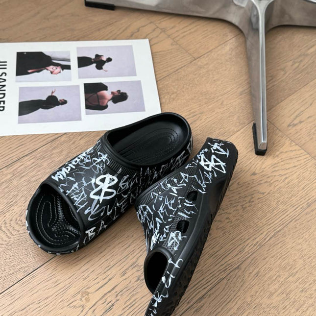 POOL GRAFFITI CROCS SLIDE SANDALS IN BLACK AND WHITE RUBBER