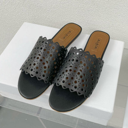 ALAIA VIENNE FLAT MULES IN BLACK LAMBSKIN